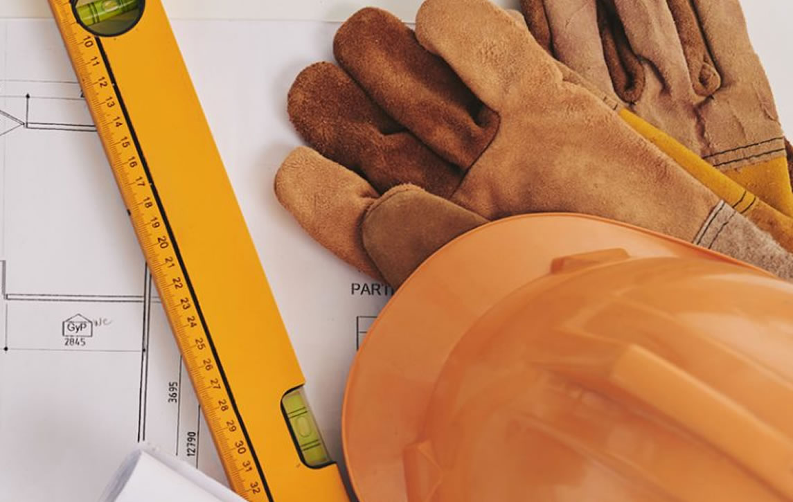 Engineering drawings, hard hat and tools on site